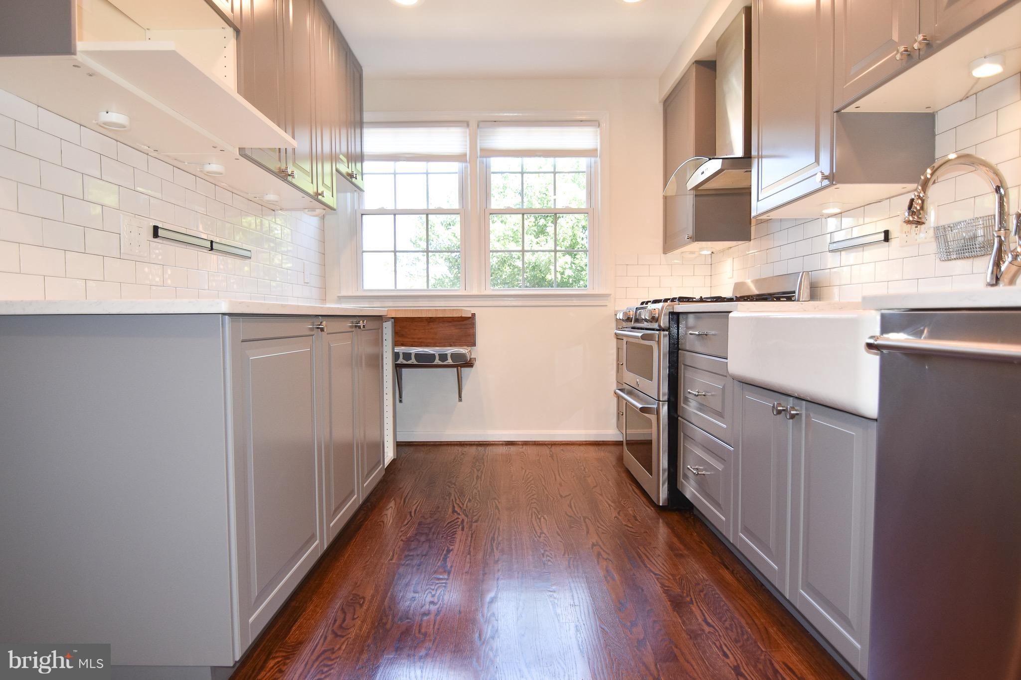3302 Spring Lane Falls Church, VA 22041 - Photo 8 of 30 a kitchen with white cabinets and wooden floor