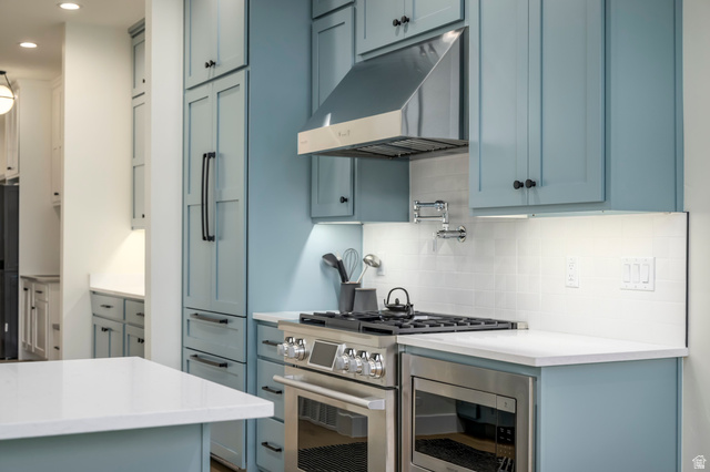 250 South Main Street, Unit 25 Alpine, UT 84004 - Photo 31 of 31 Kitchen with stainless steel appliances, blue cabinetry, decorative backsplash, and light stone countertops