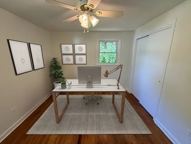 a view of a workspace with furniture and a window