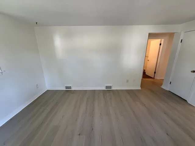 an empty room with wooden floor and closet