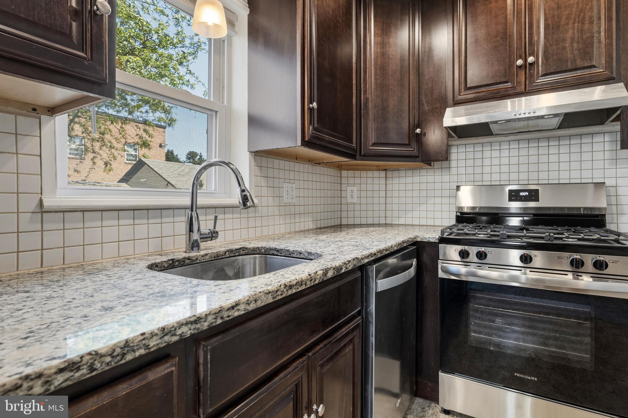 229 Wayne Avenue Narberth, PA 19072 - Photo 16 of 35 a kitchen with granite countertop a sink stove and cabinets