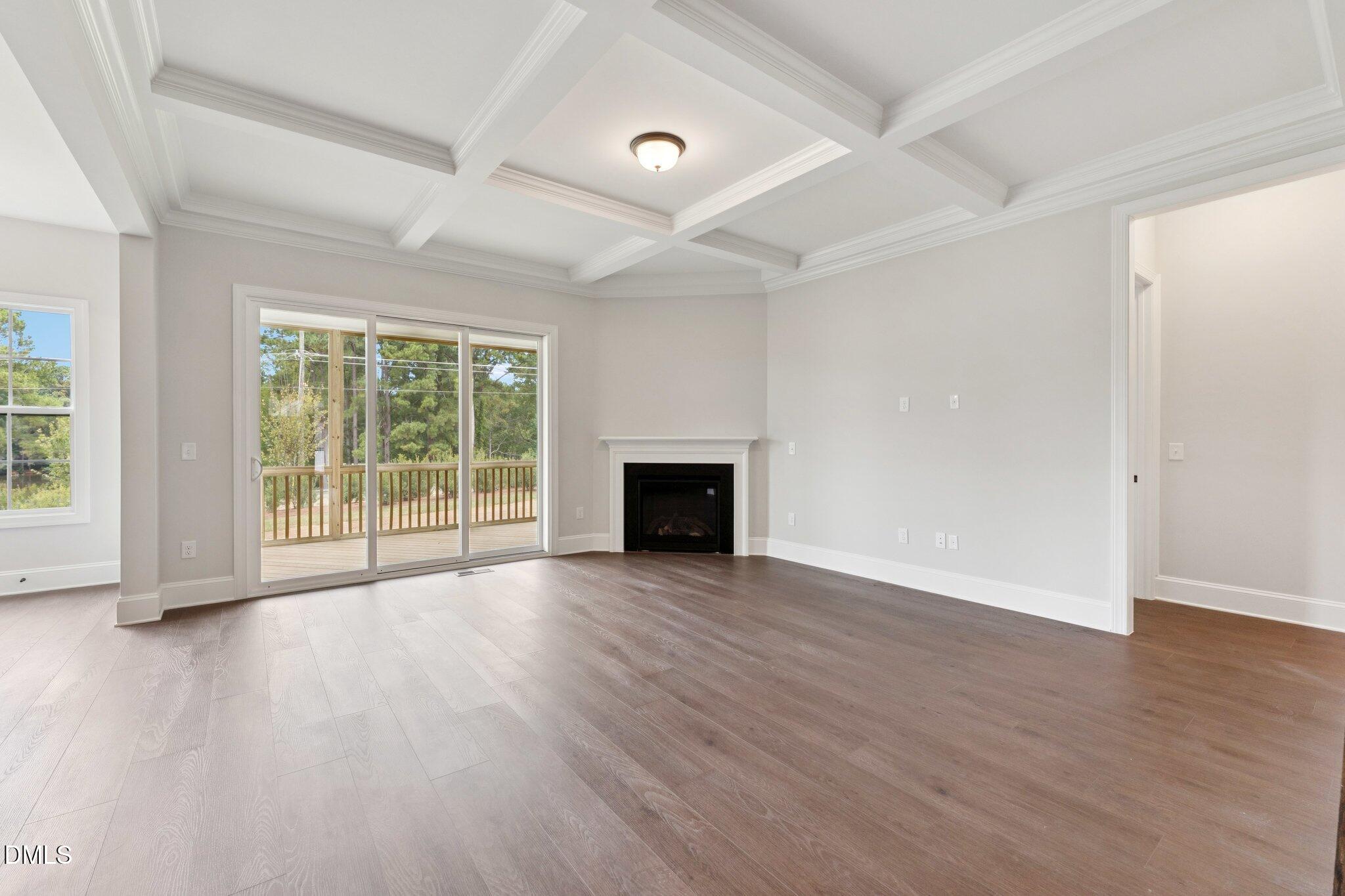 269 Ridge Road Chapel Hill, NC 27516 - Photo 6 of 41 an empty room with wooden floor and fireplace
