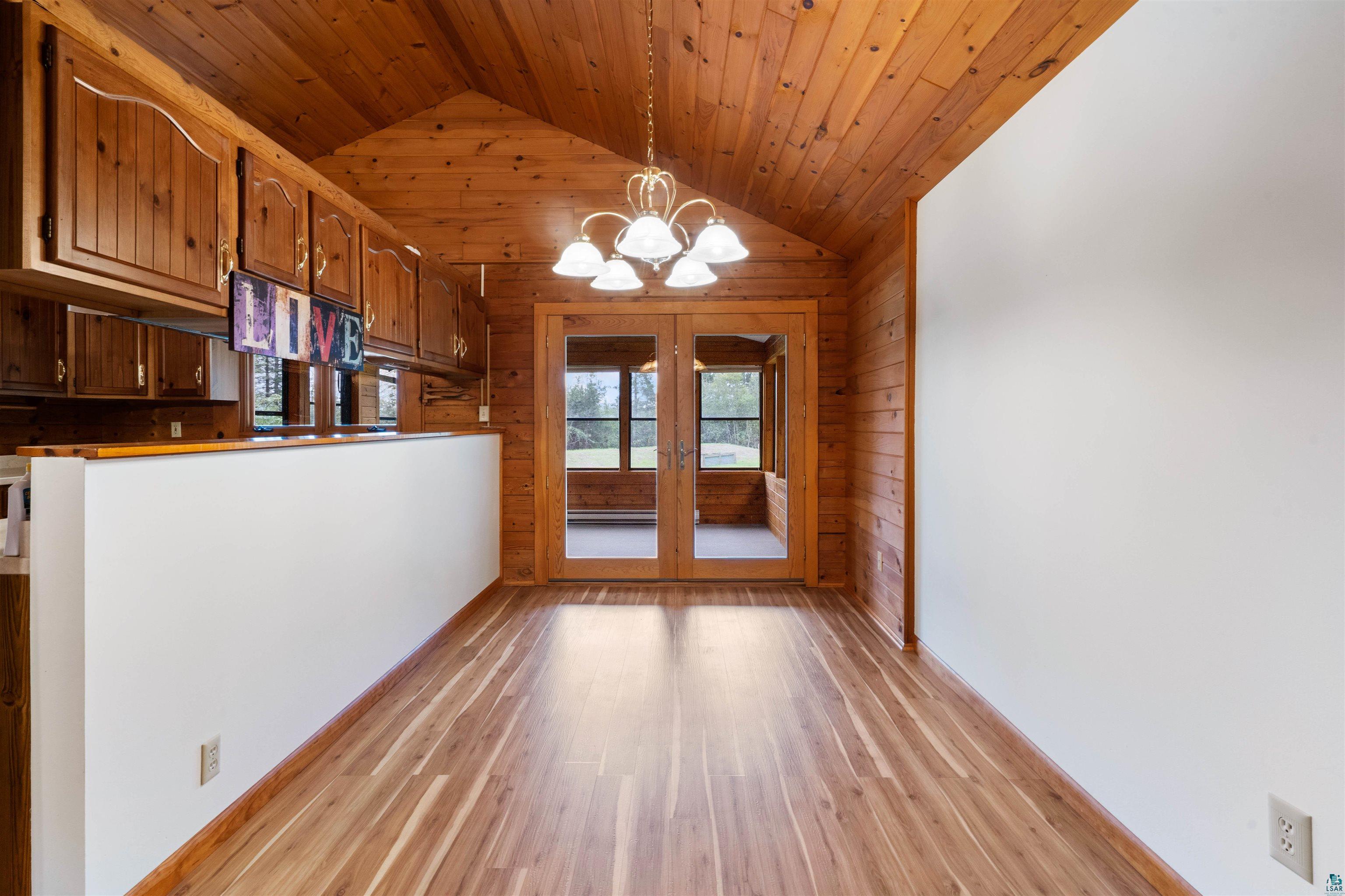 5373 Lester River Road Duluth, MN 55804 - Photo 14 of 39 Vaulted wood-paneled ceiling, wood-finish flooring, wood-paneled walls, built-in wood cabinetry, and French doors leading to an enclosed space