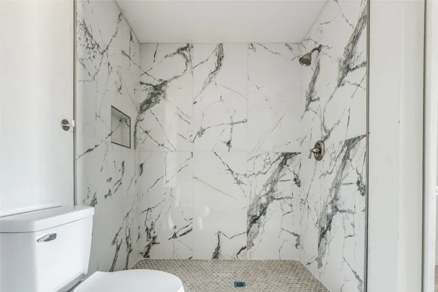 a bathroom with a toilet and a shower curtain