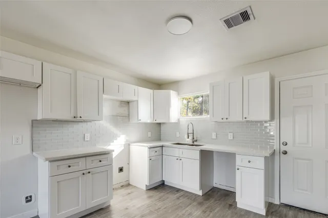 a kitchen with white cabinets appliances and a sink