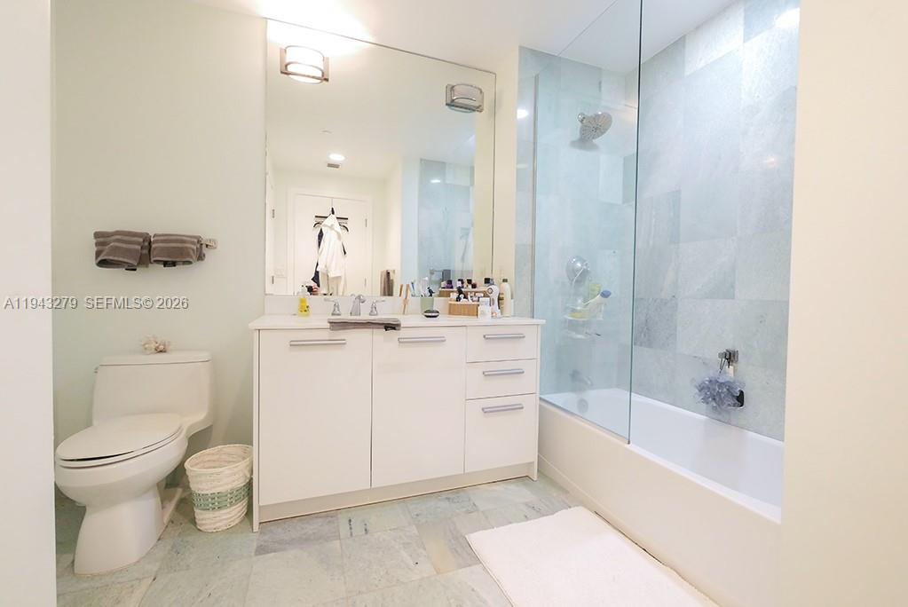 1050 Brickell Avenue, Unit 3206 Miami, FL 33131 - Photo 8 of 13 a bathroom with a sink a toilet and a large mirror