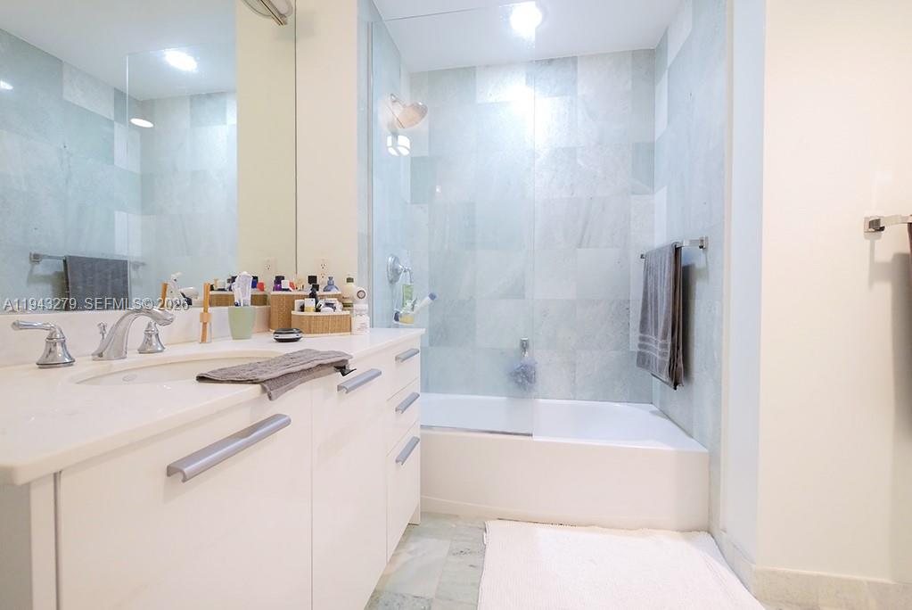 1050 Brickell Avenue, Unit 3206 Miami, FL 33131 - Photo 9 of 13 a bathroom with a tub sink and mirror