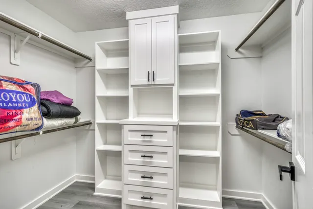 a view of walk in closet with empty racks