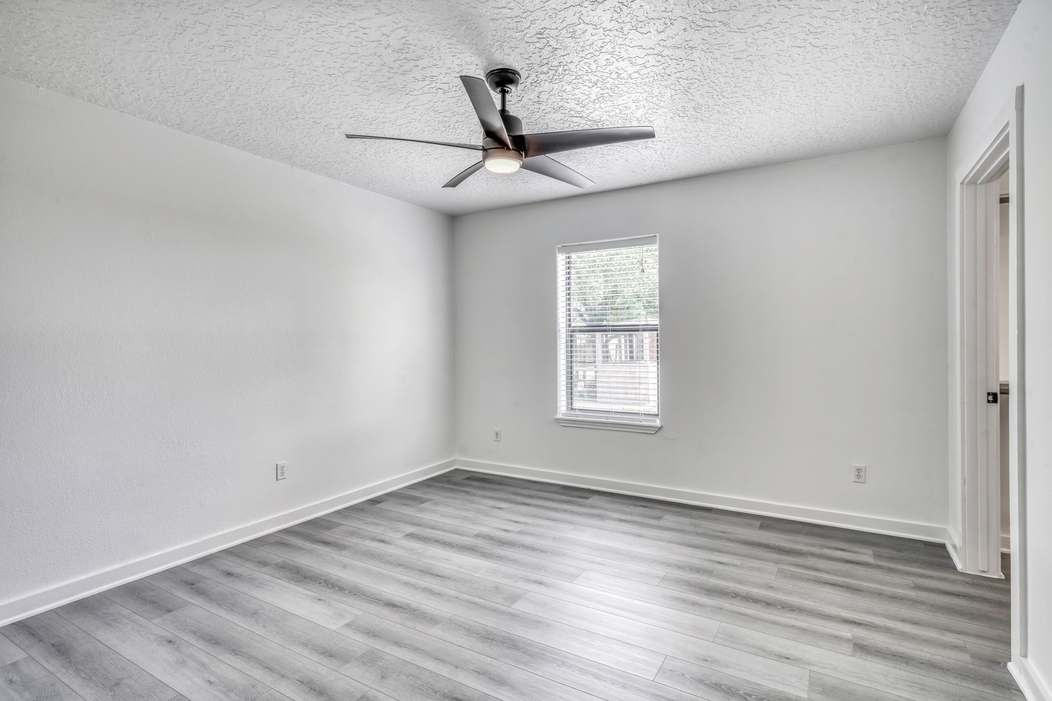 2266 Dutton Lane Madisonville, TX 77864 - Photo 22 of 50 an empty room with wooden floor ceiling fan and windows
