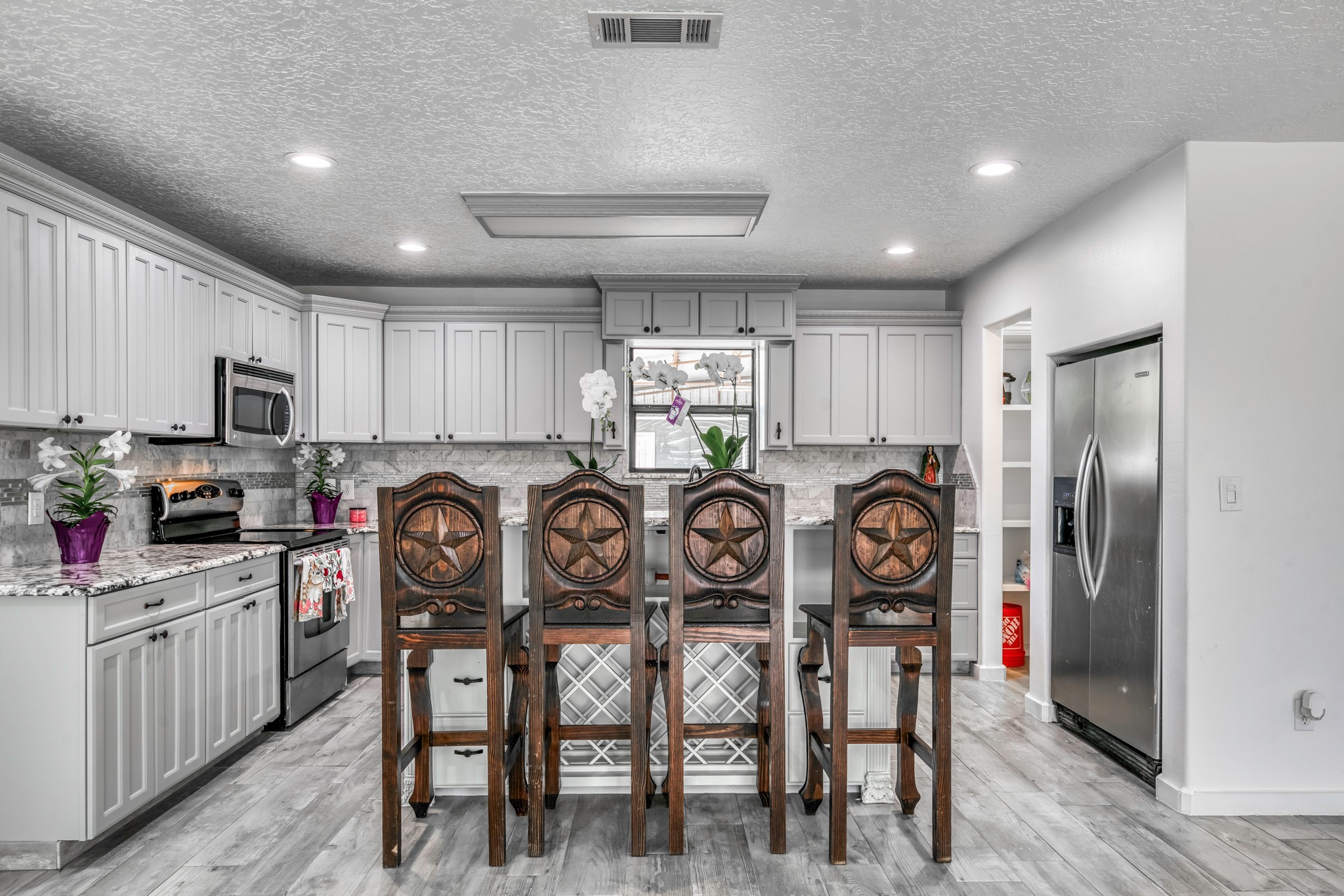 2266 Dutton Lane Madisonville, TX 77864 - Photo 10 of 50 a kitchen with granite countertop a table chairs refrigerator and cabinets