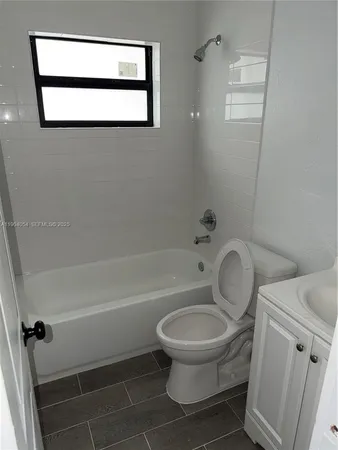 a white toilet sitting next to a bath tub