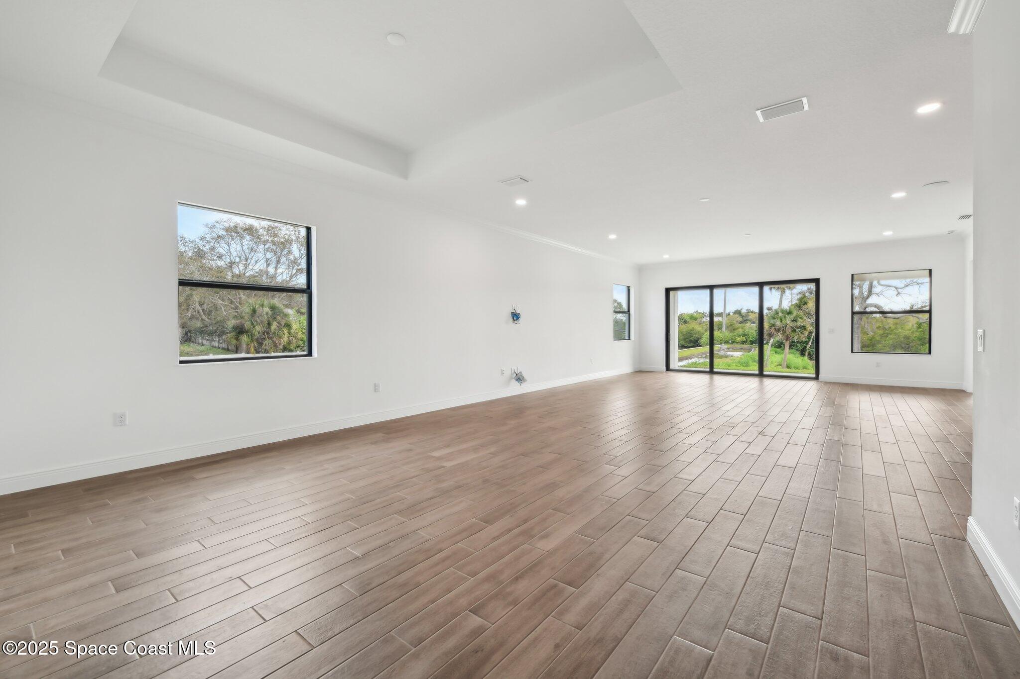 1405 Windchime Lane Melbourne, FL 32935 - Photo 13 of 48 an empty room with wooden floor and windows
