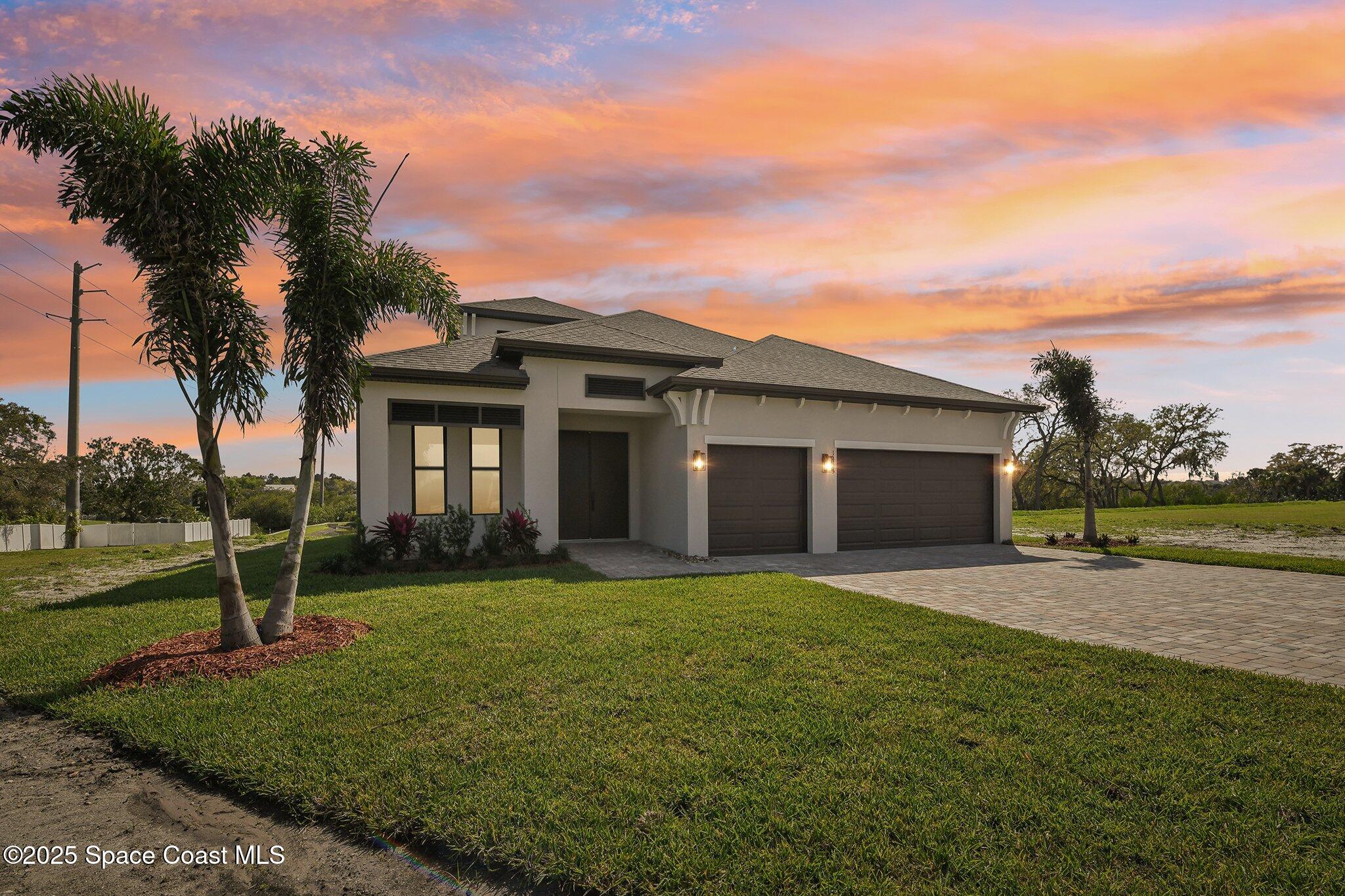 1405 Windchime Lane Melbourne, FL 32935 - Photo 2 of 48 a view of a house with a yard and palm trees
