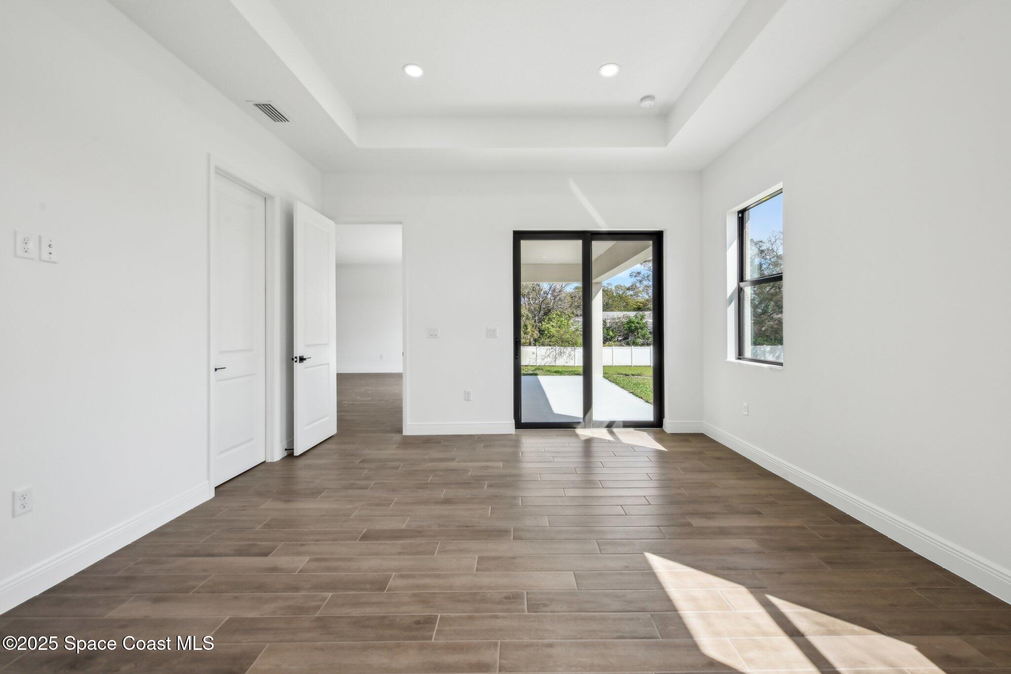 1405 Windchime Lane Melbourne, FL 32935 - Photo 23 of 48 wooden floor in an empty room with a window