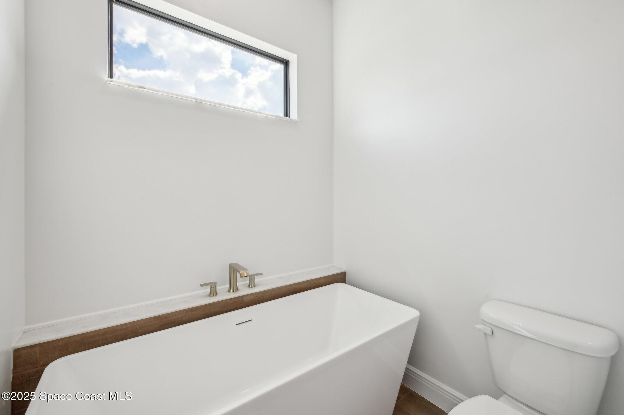 1405 Windchime Lane Melbourne, FL 32935 - Photo 26 of 48 a bathroom with a toilet a sink and mirror