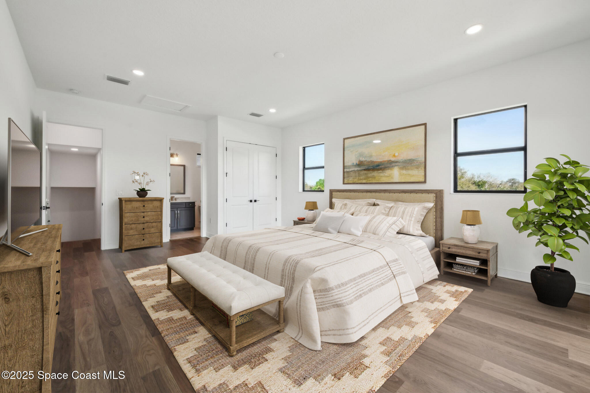 1405 Windchime Lane Melbourne, FL 32935 - Photo 31 of 48 a spacious bedroom with a bed a couch and paintings on the wall