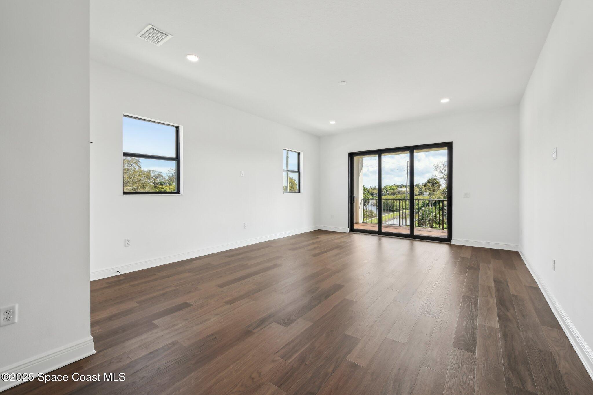 1405 Windchime Lane Melbourne, FL 32935 - Photo 32 of 48 an empty room with wooden floor and windows