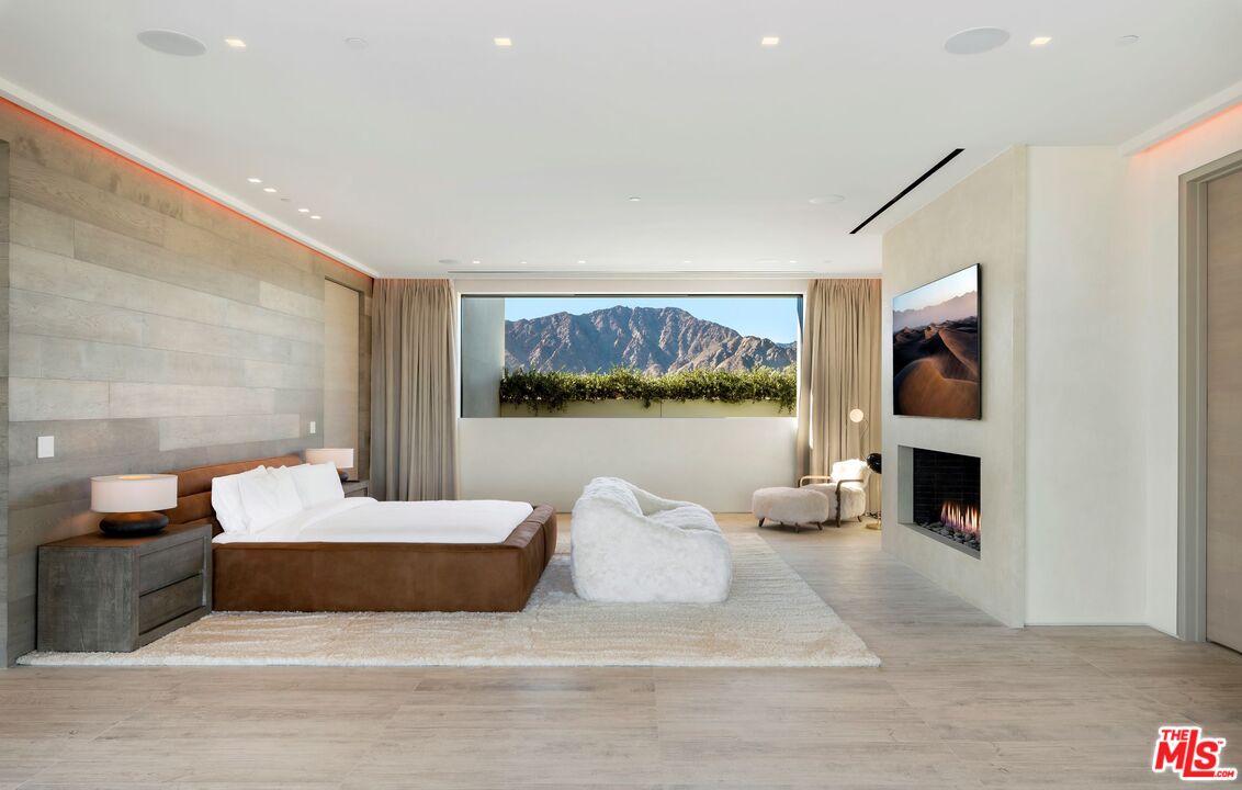 53804 Ross Avenue La Quinta, CA 92253 - Photo 25 of 29 a bedroom with a large bed and a fireplace