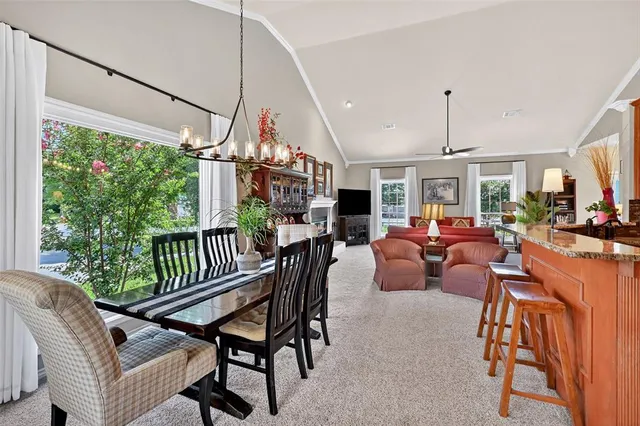 a view of a dining room and livingroom with furniture wooden floor a chandelier