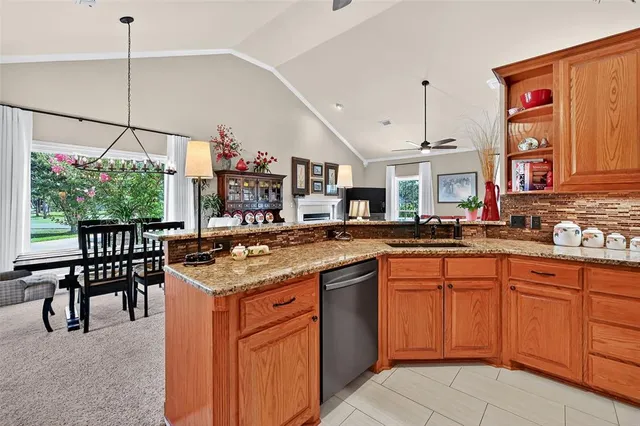a kitchen with stainless steel appliances granite countertop table chairs and a large window