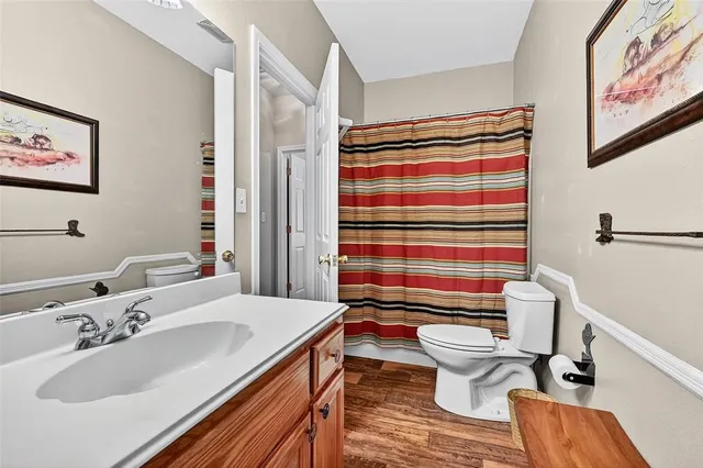 a bathroom with a sink toilet mirror and shower