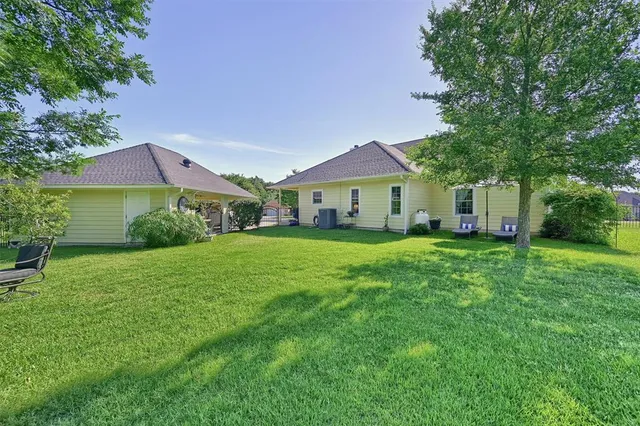 a front view of a house with a yard and trees
