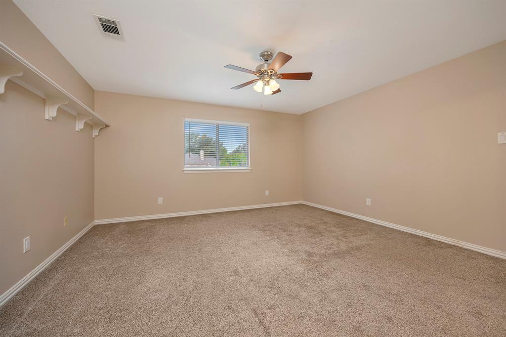 4008 Ramsgate Court Colleyville, TX 76034 - Photo 25 of 33 Expansive carpeted room featuring a ceiling fan with light fixture, a window with horizontal blinds, built-in wall shelving, and baseboard molding
