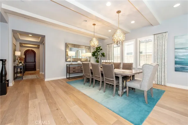 a view of a dining room with furniture a chandelier and wooden floor