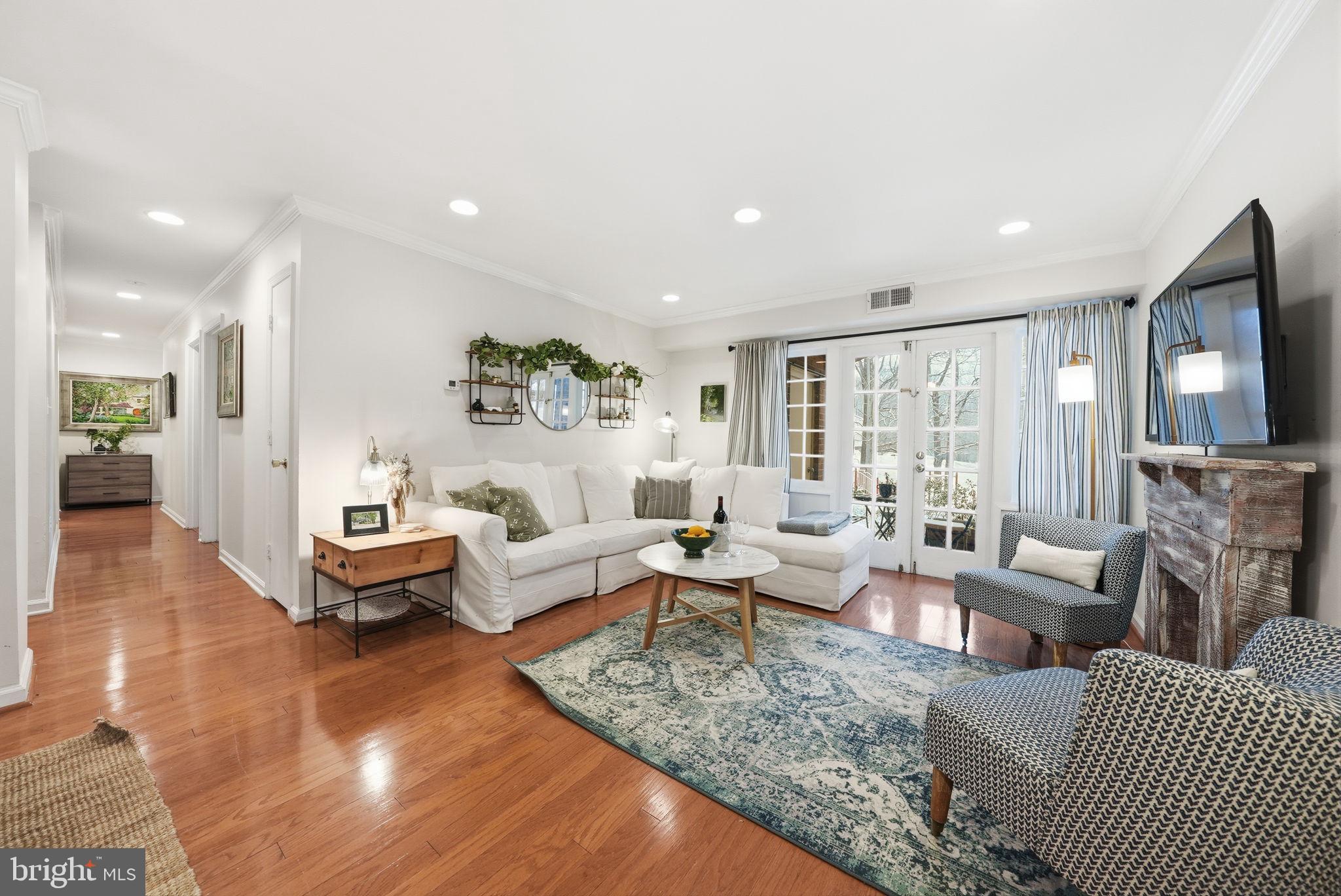 8231 Kings Charter Lane, Unit 108 Springfield, VA 22152 - Photo 3 of 37 a living room with fireplace furniture and a flat screen tv