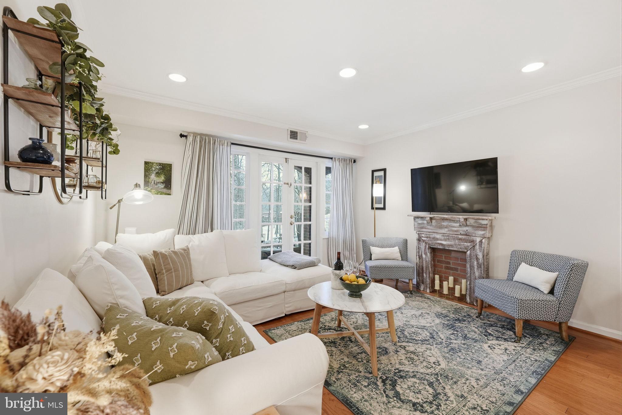8231 Kings Charter Lane, Unit 108 Springfield, VA 22152 - Photo 5 of 37 a living room with furniture and a flat screen tv