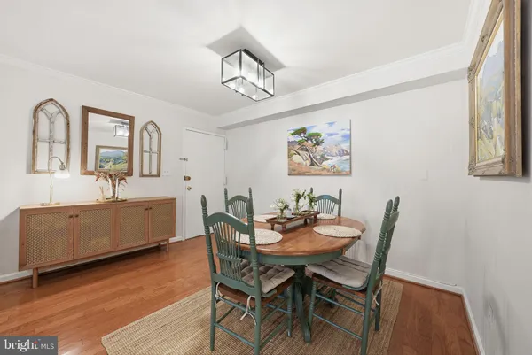 a view of a dining room with furniture a rug and wooden floor