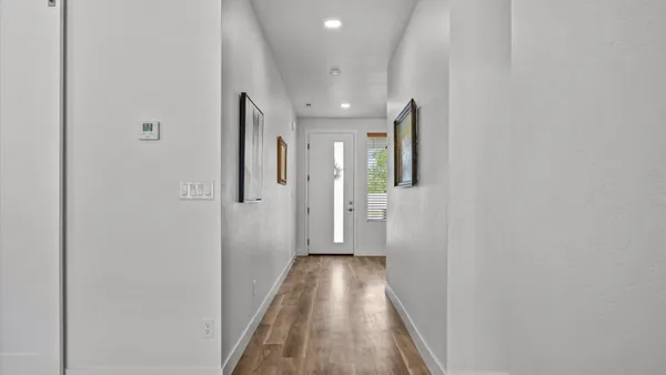 a view of a hallway with wooden floor