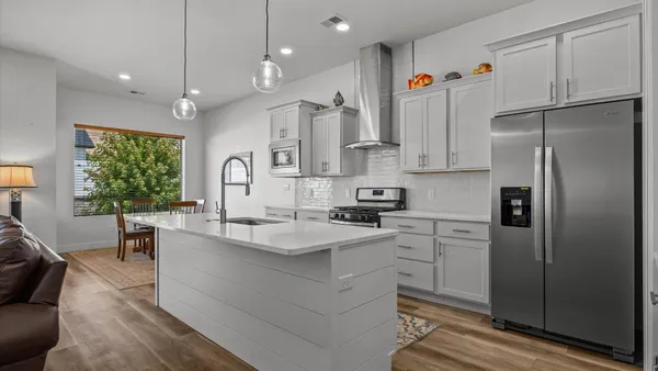 a kitchen with white cabinets and refrigerator