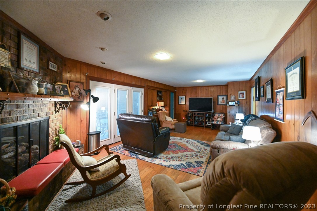 811 Butler Island Road Roseboro, NC 28382 - Photo 13 of 43 a living room with furniture a flat screen tv and a fireplace