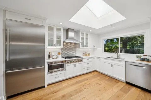 a kitchen with white cabinets and white appliances