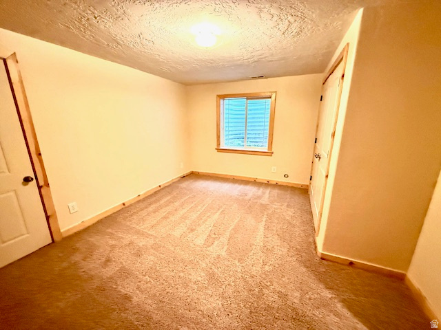 596 East 4190th Street North, Unit 5 Provo, UT 84604 - Photo 31 of 38 Unfurnished bedroom with light carpet, a textured ceiling, and a closet