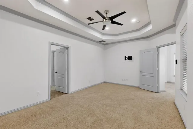 en empty room with fan and a ceiling fan