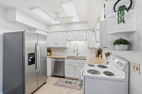 a kitchen with a white stainless steel appliances cabinets and a counter top space