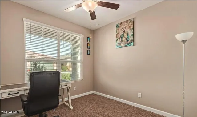 a view of a workspace with furniture and a window
