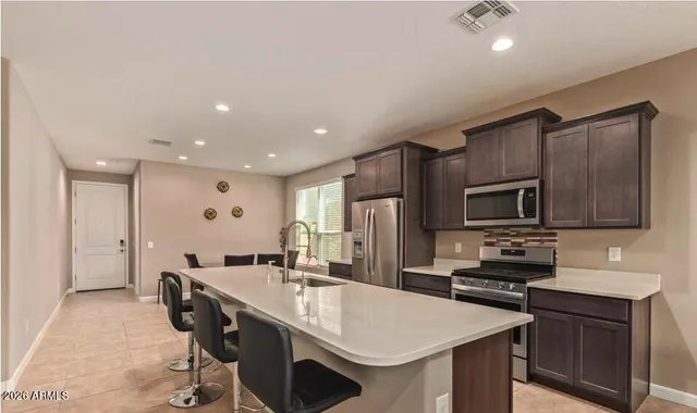 a kitchen with kitchen island a sink stove and refrigerator