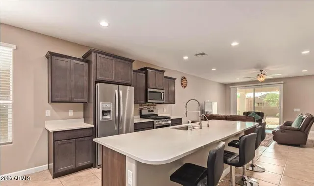 a kitchen with granite countertop a sink a counter space stainless steel appliances and cabinets