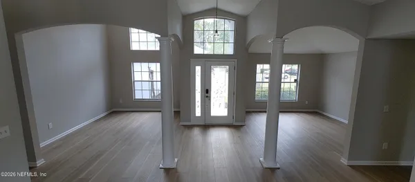 a view of a room with wooden flooring and lots of windows