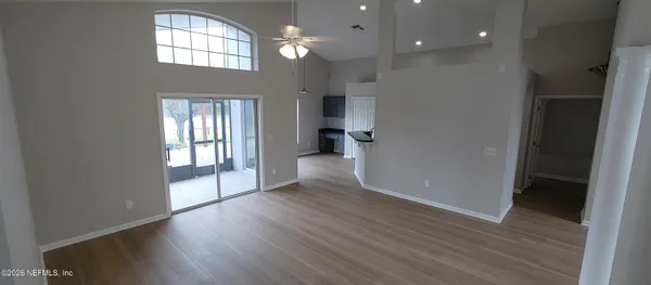 an empty room with wooden floor and windows