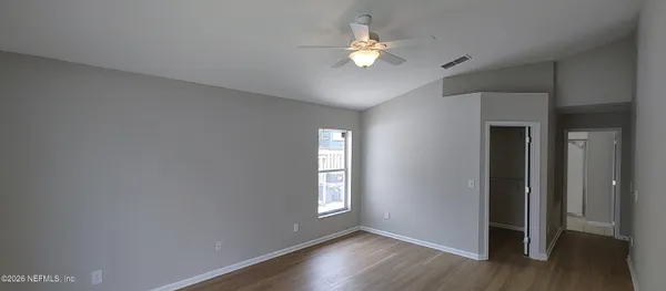 an empty room with wooden floor and window