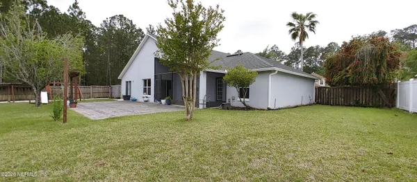 a view of a house with backyard and tree