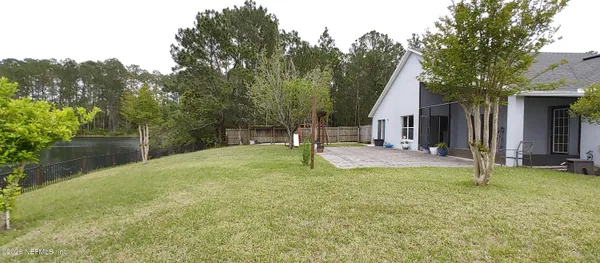 a view of a house with backyard and trees