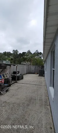 a view of terrace with couple of cars parked in front of house