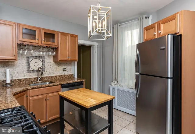 a kitchen with stainless steel appliances granite countertop a refrigerator a sink a stove and island