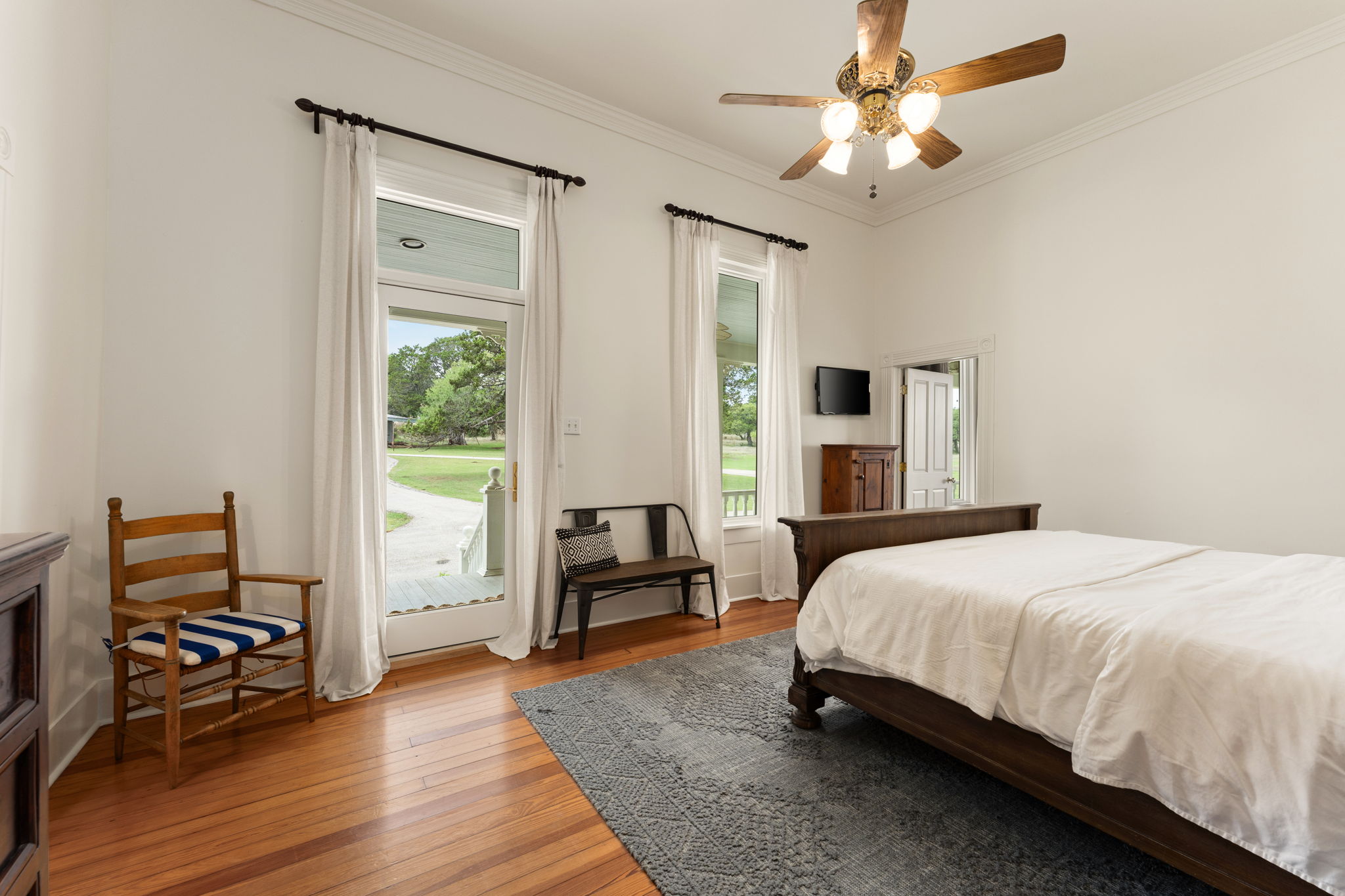 3409 Gatlin Creek Road Dripping Springs, TX 78620 - Photo 15 of 40 a bedroom with a bed and a chandelier