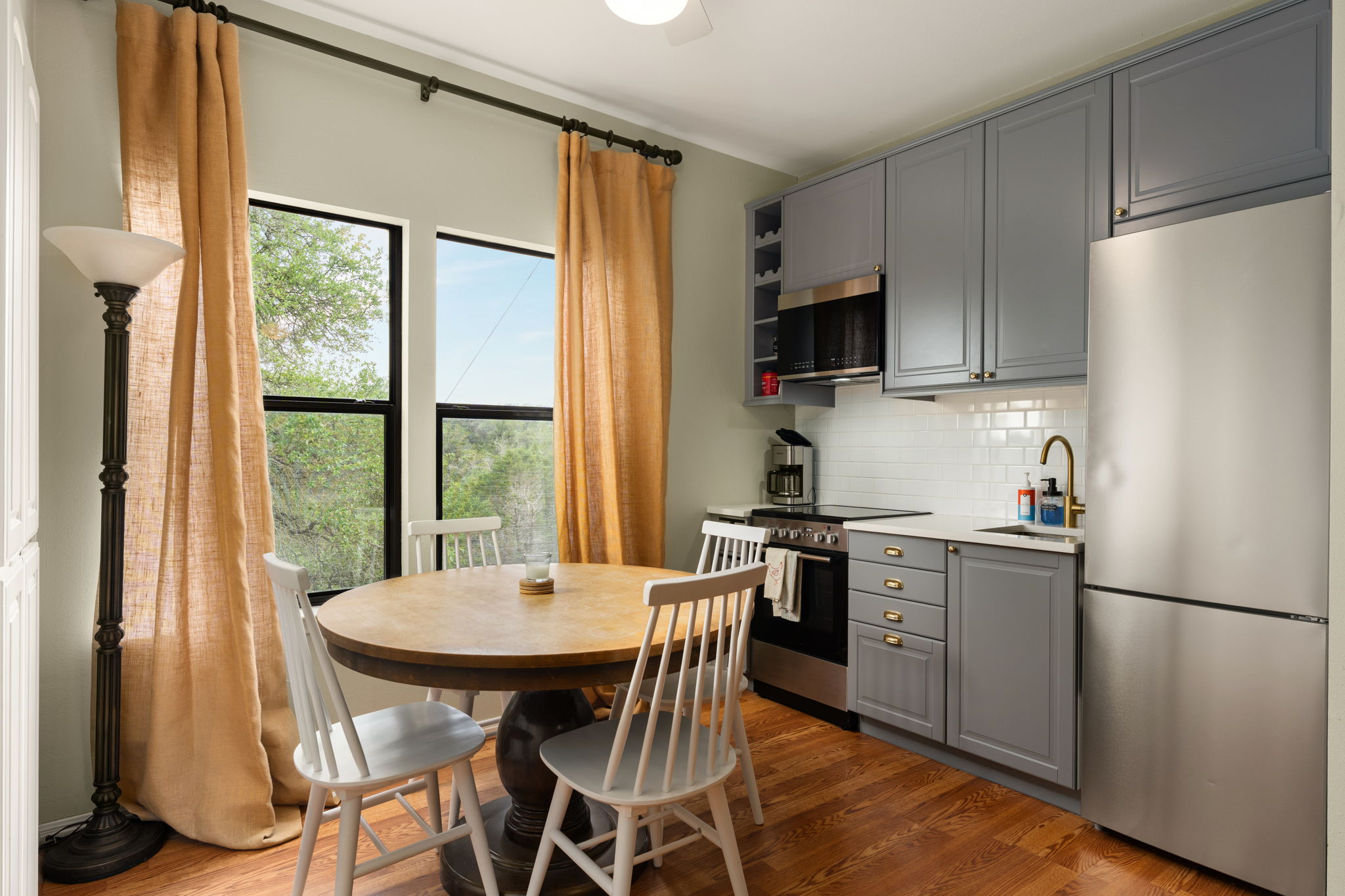 3409 Gatlin Creek Road Dripping Springs, TX 78620 - Photo 35 of 40 a kitchen with a table chairs refrigerator and microwave